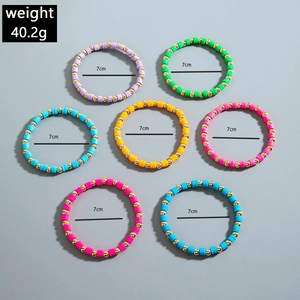 Close-up of 7 colorful bohemian beaded bracelets with 7cm diameter and gold metal spacers