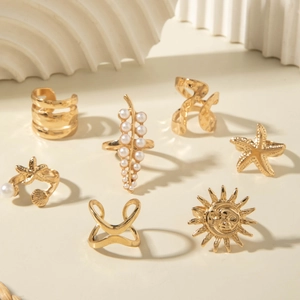 Detail of 7-piece gold alloy ring set featuring starfish, sun, and pearl bohemian designs