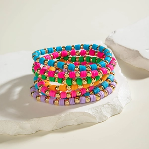 Close-up of bohemian multilayer colorful clay disc and gold bead elastic bracelets