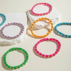 Detail of colorful polymer clay bead bracelets with golden accents on stone decor