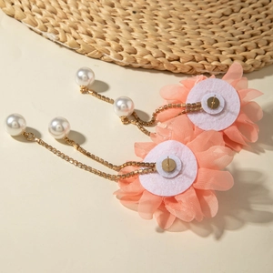Detail of pink tulle flower earrings with hanging gold chains and faux pearls