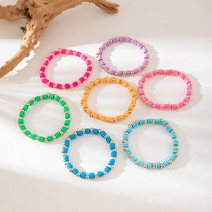 Detailed set of 7 colorful bohemian beaded bracelets with clay discs and gold beads