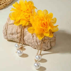Detail of yellow mesh flower earrings with rhinestone tassels and faux pearls