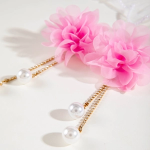 Detailed macro view of pink tulle flower earrings with pearl tassels and crystal accents