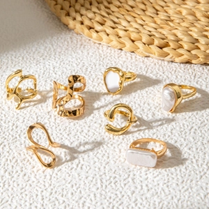 Set of minimalist geometric gold rings with pearls and liquid metal designs