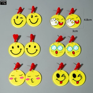 Detail showing six pairs of yellow acrylic smiley earrings with red heart studs and glitter