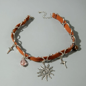 Detail of vintage choker featuring sun spiral pendant, cross stars and pink glass beads
