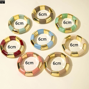 Vue à plat de huit bracelets extensibles bohèmes colorés avec segments dorés et perles