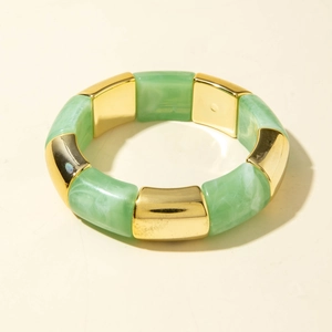 Détails des perles en résine marbrée verte et tubes dorés sur bracelet élastique
