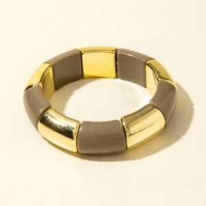 Détail des segments en métal doré et résine taupe d'un bracelet extensible bohème