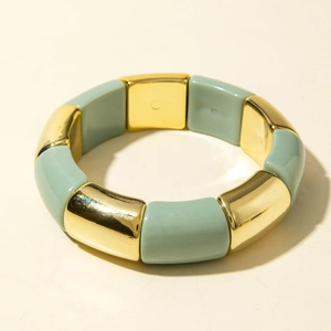 Détail du bracelet élastique géométrique vert clair et doré avec finition polie