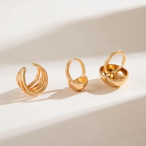 Detailed view of polished gold geometric earring set featuring curved chunky designs