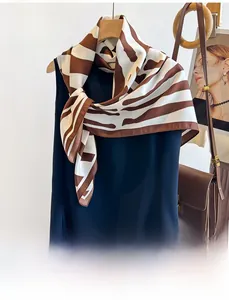 Detailed close-up of brown and white zebra print twill silk scarf with smooth texture