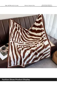 Close-up of zebra print polyester scarf 90x90cm with rolled edges on a leather surface