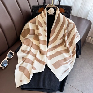 Elegant 90cm striped silk scarf in beige and brown hanging on a hanger for women