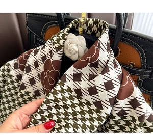 Detail of silk scarf with houndstooth and camellia patterns showing texture and drape