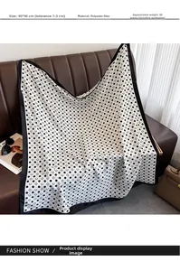 Detailansicht eines 90x90cm Polyester-Halstuchs mit schwarzen Kreismustern auf Sofa