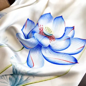 Macro detail of silk scarf showing refined stitching and elegant blue lotus print