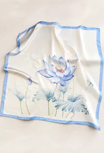 Close-up of elegant lotus silk scarf with smooth satin texture and blue floral patterns