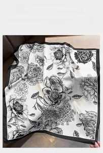 Detail of elegant silk scarf with vintage black floral print on ivory fabric