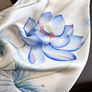 Silk scarf with vintage blue lotus pattern and smooth texture on premium leather backdrop