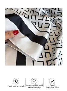 Detail eines weichen Twill-Seidenschals mit schwarzen geometrischen Mustern auf Weiß