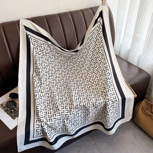 Klassisches schwarz-weißes Seidentuch mit geometrischem Muster elegant auf Sofa dekoriert