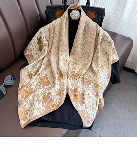 Detail of floral printed twill silk shawl with beige patterns draped over black clothes