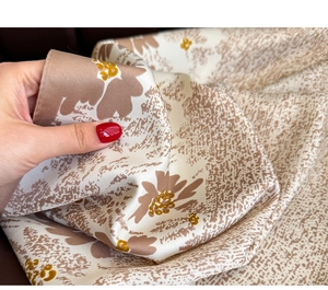 Close-up of soft floral silk scarf fabric showing smooth texture and elegant drape