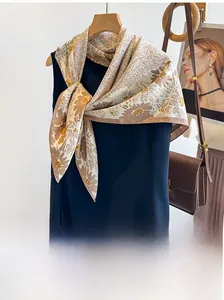 Detailed view of floral silk twill scarf in beige and yellow styled with a navy blue top