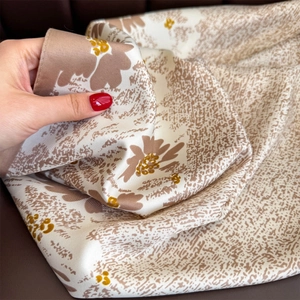 Detail of twill silk scarf showing floral print texture and soft satin finish