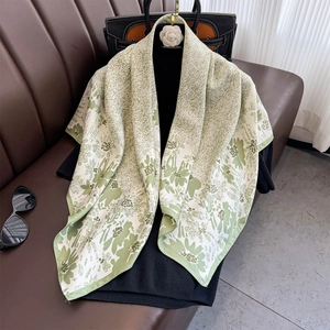 Avocado green twill silk scarf with floral prints worn as an elegant summer shawl