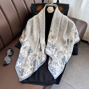Detailed view of floral print silk scarf with roll-edged hem and soft texture