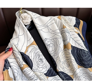 Close-up of vintage floral silk scarf with elegant camellia patterns and satin luster