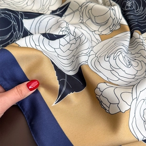 Close-up of twill silk scarf showing elegant camellia print and fine edge stitching
