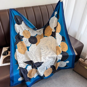 Detailed view of large vintage rose print silk scarf on a stylish leather surface