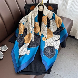 Elegant floral silk square scarf in blue and yellow draped on a mannequin