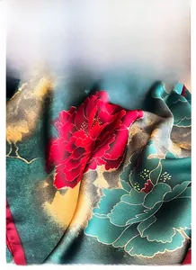 Dettaglio di una sciarpa in raso verde scuro con peony rosse e drappeggio setoso