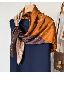 Close-up of silk scarf with brown polka dots and geometric patterns on a hanger