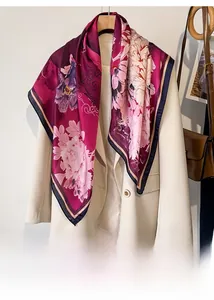 Detail of elegant silk scarf with purple floral pattern draped on a cream blazer