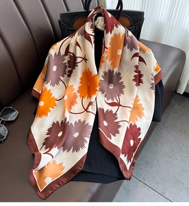 Detail of silk scarf featuring elegant floral dahlias and smooth glossy texture