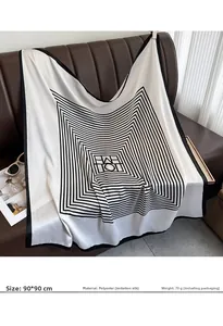 Detail of 90x90cm faux silk scarf with black and white geometric pattern on leather