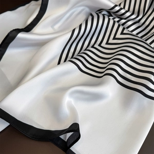 Elegant silk-like scarf featuring modern black geometric stripes on a cream satin base