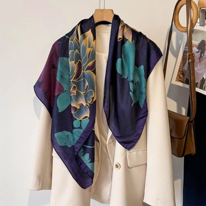Elegant floral lotus pattern silk square scarf draped on a chic beige suit jacket