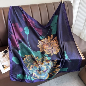 Elegant purple lotus floral square silk scarf draped on a brown leather sofa for decor
