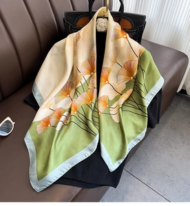 Dettaglio macro di un grande foulard di seta con motivo a foglie di ginkgo e lustro setoso