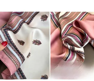 Detail of silk-like satin square scarf featuring pink wavy patterns and glossy texture