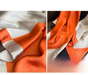 Close-up of vibrant orange and silver satin scarf showing smooth texture and drape