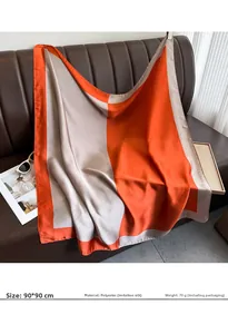Detail of 90x90cm orange and grey silk satin square scarf draped on a leather sofa