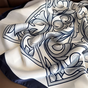Luxurious ivory satin scarf with navy baroque floral patterns and silk-like sheen